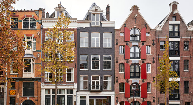 Amsterdam Netherlands dancing houses with traditional deutch windows. Landmark in old european city. Architectural details windows and roofs.