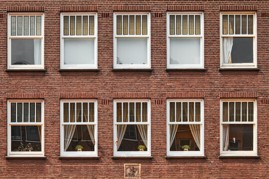 Traditional architecture of Amsterdam, Netherlands. Windows of brick houses in a row. Old town buildings details.