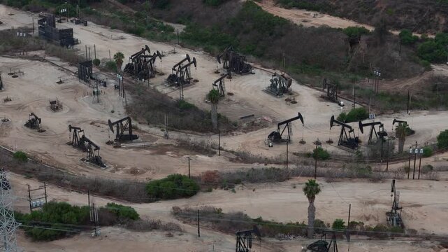 Aerial view of oil pump jacks operating in the industrial landscape of Baldwin Hills, Los Angeles, California, United States.