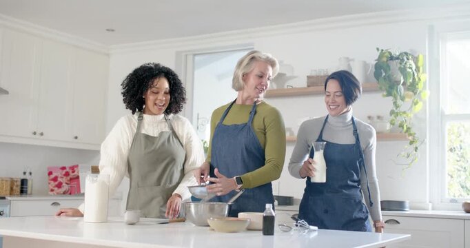 Diverse female friends in aprons starting bake in kitchen, sifting flour, pouring milk, whisking