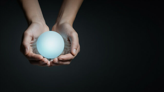 Hands gently holding glowing blue orb with soft light