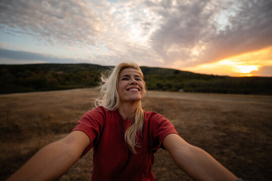 Happy woman enjoying freedom in nature at sunset