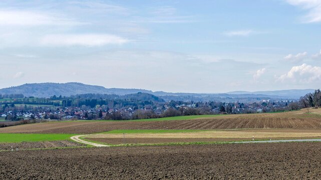Gemeinde Rielasingen-Worblingen an der Radolfzeller Aach.(Landkreis Konstanz) mit dem Glockenturm der St.Nikolaus. H&uuml;gelige l&auml;ndliche Landschaft der Hegau-Vulkanregion mit gepfl&uuml;gten Feldern 