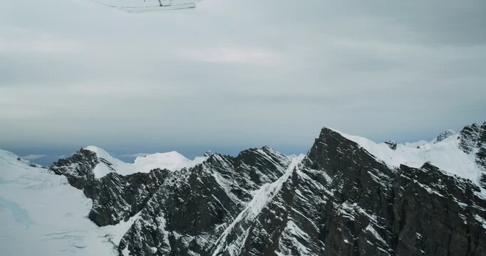 Aerial view of Mount McKinley with snow-covered rugged peaks seen from a small plane in Denali Borough, Alaska, United States.