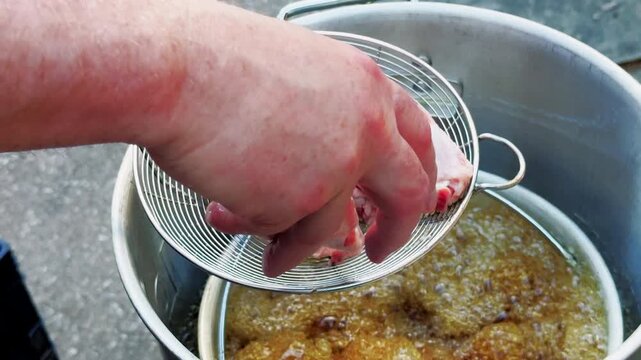 Raw Chicken Wings Lowered Into Bubbling Hot Oil