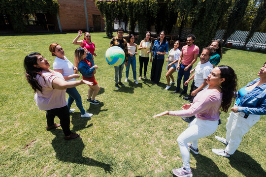 group of latin friends playing volleyball game in public park in Mexico Latin America. multicultural hispanic teamwork having fun together outdoors