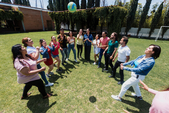 group of latin friends playing volleyball game in public park in Mexico Latin America. multicultural hispanic teamwork having fun together outdoors