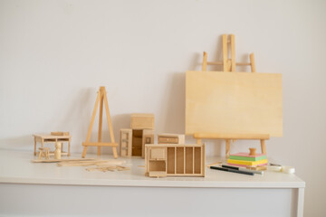 Wooden miniature shelf and canvas easel with parts on white surface, workshop where hands finally rest, process worth showing. Still life. Concept of workshop of patient handmade hobby © iwavephoto