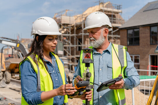Construction workers discuss project details at a building site in broad daylight