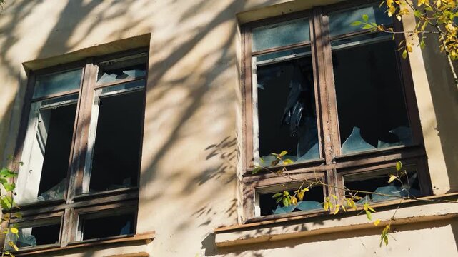 A broken window on a building with broken glass, perfect for a scene of vandalism or a cautionary tale