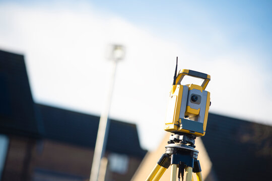 Surveying equipment set up on a construction site during the day under clear blue skies