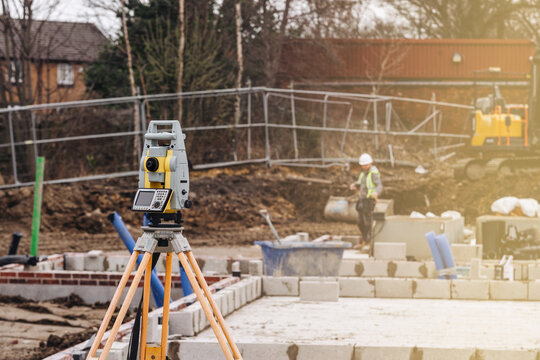 Construction site with surveying equipment and workers engaged in building activity