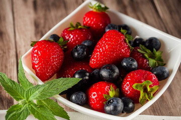 Pancakes with strawberries, blueberries and mint © Yuliia Kosmeniuk