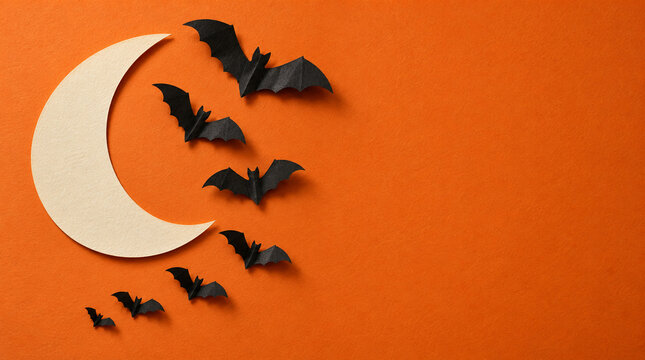 Murci&eacute;lagos de papel rodean luna sobre fondo naranja