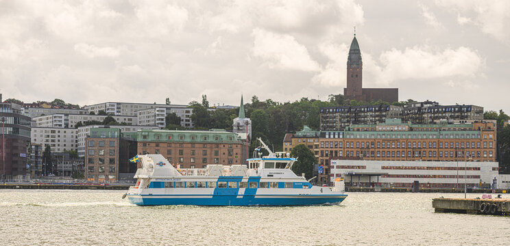 Gothenburg, Sweden - July 26 2026: Passenger ferry crossing Gothenburg harbor beneath dramatic cloudy skyline.
