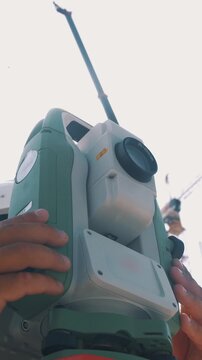 A professional electronic surveying total station with the lens in close-up view during operation 