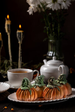 Pumpkin shaped meringues with tea for autumn celebration