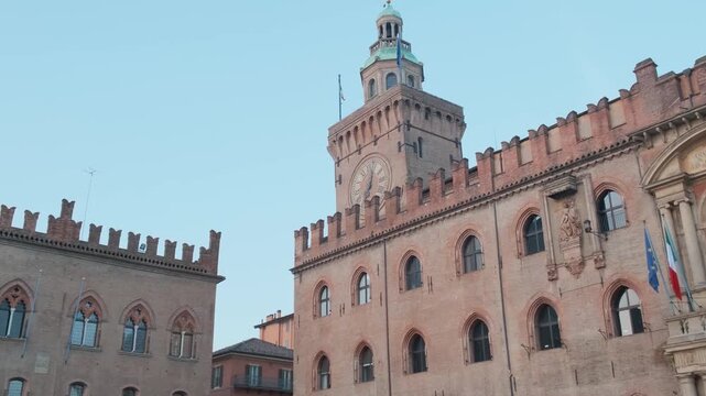 Palazzo dAccursio with clock tower and medieval brick facade on Piazza Maggiore in Bologna old town, Emilia-Romagna, Italy. Italian architecture, European city square, historic urban tourism