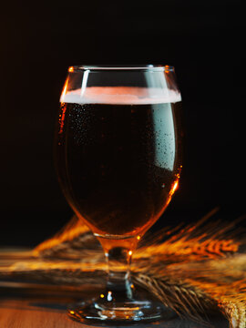 A beer glass on a wooden table.