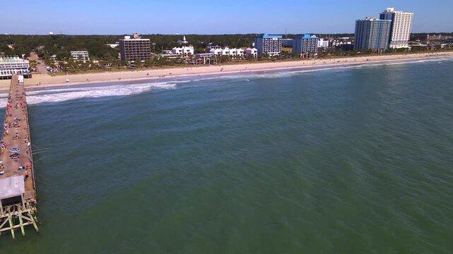 camera pans left across water until the pier Myrtle Beach  aligns with the beachfront.
