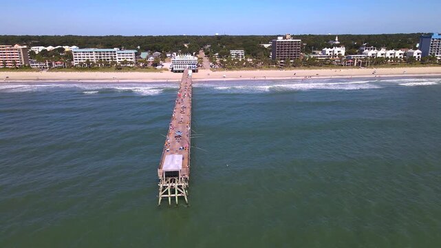 rightward aerial panorama moves from an ocean pier toward the Myrtle Beach coastline.
