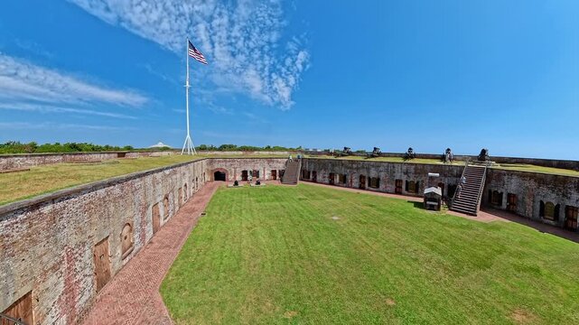 An expanding view follows the lawn toward stairs and artillery above brick chambers.
