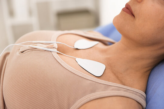Patient with ECG electrodes attached to her chest in clinic, closeup
