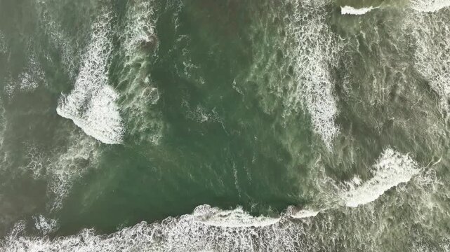 Aerial view of the powerful Pacitan Rip Current with churning white foam and dark green ocean water off the coast of Pacitan, East Java, Indonesia.