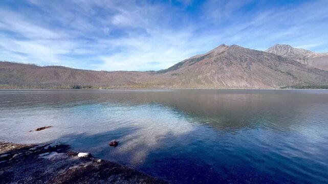 Pan view of mountain range, including Stanton Mountain and Mount Vaught on the banks of Lake McDonald in Glacier National Park
