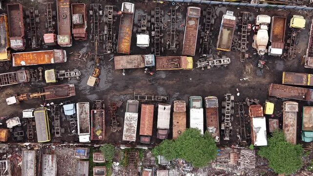 Aerial view of a truck scrapyard with numerous parked trailers and industrial vehicles in Chennai, Tamil Nadu, India.
