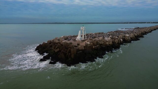 Escollera breakwater at South Beach during sunrise near Panuco river entrance, aerial drone view of wavy ocean water with coastline horizon background in Veracruz near Tampico region, Mexico