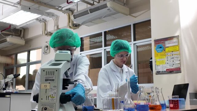 Laboratory room. Female scientists conducting laboratory research with colorful chemical samples. Using test tubes flasks and microscopes for scientific analysis and experimentation. Bio or chemical
