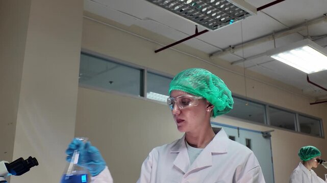 Laboratory room. Female scientists conducting laboratory research with colorful chemical samples. Using test tubes flasks and microscopes for scientific analysis and experimentation. Bio or chemical