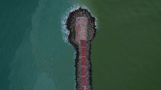 Escollera tip top down aerial drone view showing water boundary effect at Miramar beach during sunrise, turquoise Gulf ocean meeting green Panuco river tide in Ciudad Madero Tamaulipas