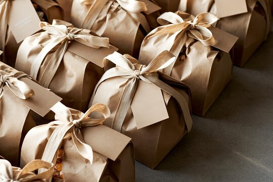 Brown paper gift boxes tied with fabric ribbon. Present packaging for retail sales and promotions. Boxes are ready for holiday shopping events