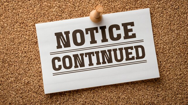 Notice continued text on white paper pinned to a corkboard background. Office communication concept for business announcements.