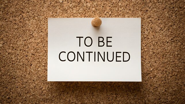 A white note displaying "TO BE CONTINUED" is pinned on a textured cork board, lit to show depth. This visually communicates ongoing processes, future plans, or unfinished.