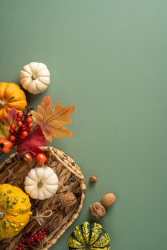 Autumn harvest still life with pumpkins, gourds and seasonal basket for Thanksgiving styling on vertical light green pastel canvas