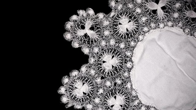 Tenerife lace, needle lace antique traditional doily also known as Spanish Sol Lace embroidery, whitework, white work, needlework. Isolated on black background, border art design, top view, vintage. 