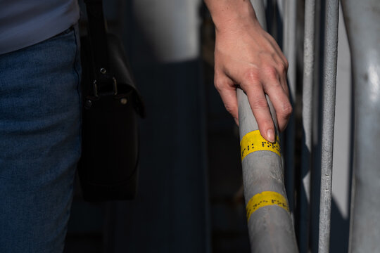 A blind woman reads the inscription on the railing of a staircase. 