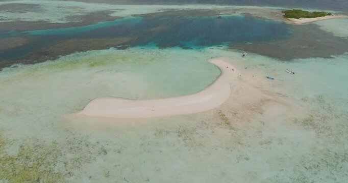 Aerial view of a white sandbar surrounded by turquoise water and coral reefs in Komodo, Nusa Tenggara Timur, Indonesia.