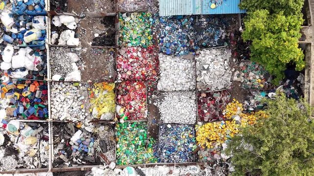 Aerial view of segregated waste plastic sorted into colorful piles for recycling in India.