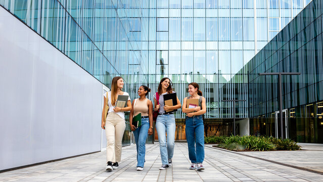 Diverse women students walking on university campus discussing