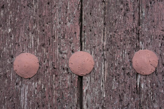 Weathered Red Wooden Door with Three Round Metal Studs