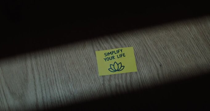 Yellow sticky note reading simplify your life on a textured surface, representing minimalism, clarity and intentional living