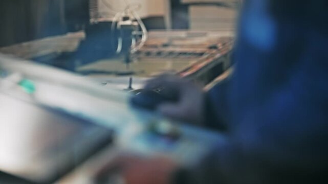 Operator Controlling Waterjet Cutting Machine in Industrial Production Plant
