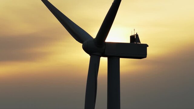 Industrial Wind Turbine Generating Renewable Energy at Golden Sunset
