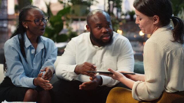 Close-up shows entrepreneurs using an AI model on a tablet during a rooftop strategy meeting, with colleagues applying machine learning to improve workflow.
