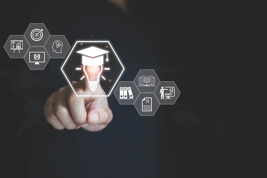 Online education and e-learning concept with a person's hand touching virtual icons of graduation, knowledge and innovation, representing digital learning, training and self development.