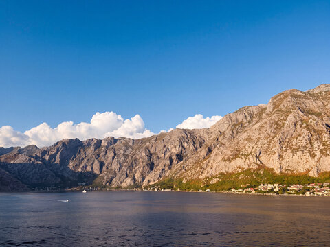 Panoramic scenic view of rocky mountains and ocean under blue sky